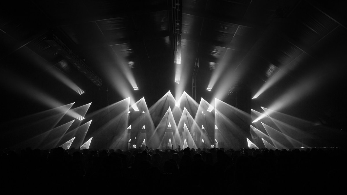 A symmetrical array of moving-head beams over a crowd.
