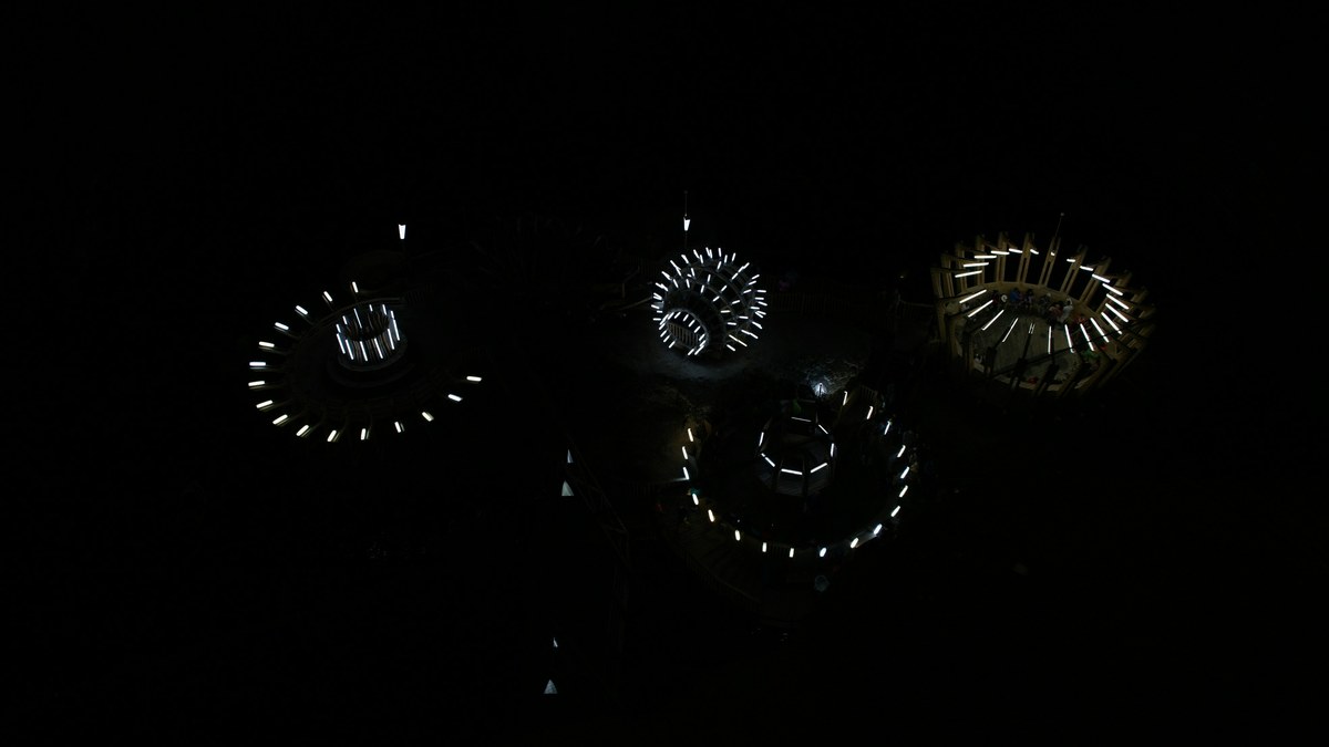 Aerial night view of circular drone light formations.