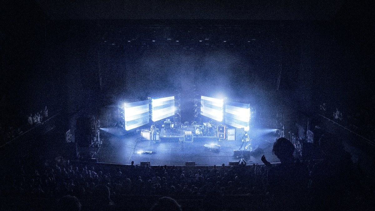 A stage framed by glowing LED video panels with a band performing.