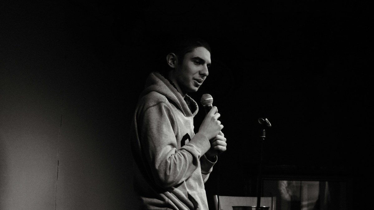 Comedian performing on a dark stage