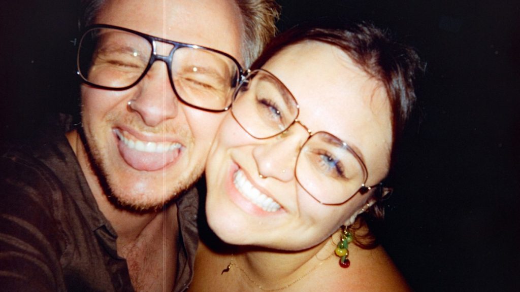 Smiling couple taking a selfie on a night out