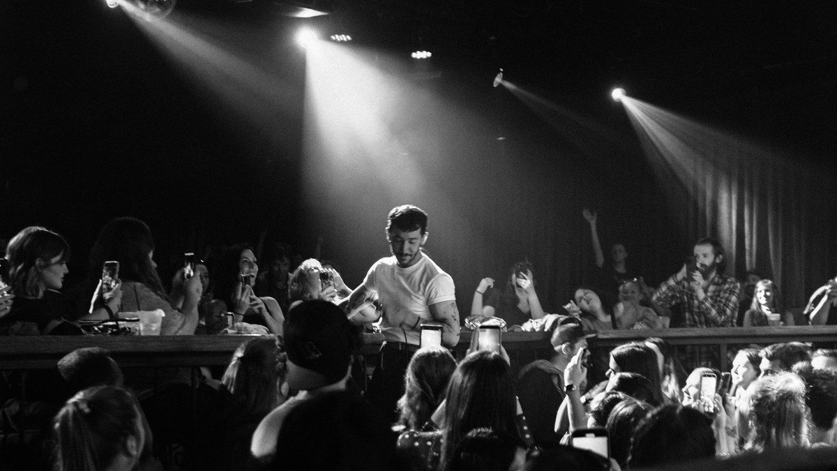 Performer surrounded by fans taking photos