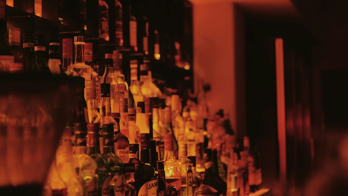 Bottles lined up on a bar shelf