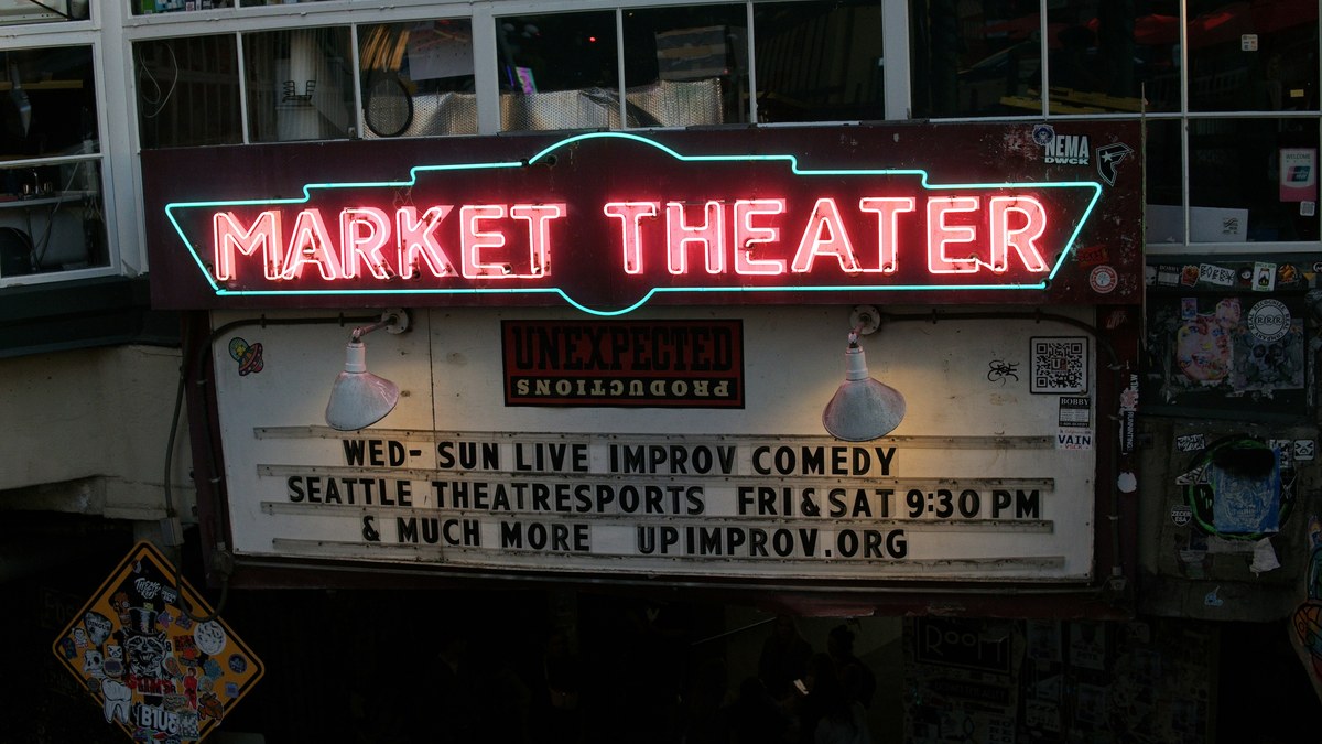 Neon Market Theater marquee advertising live improv comedy