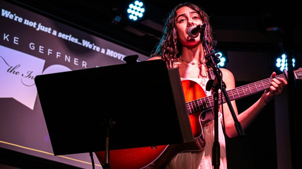 Singer performing on stage with guitar