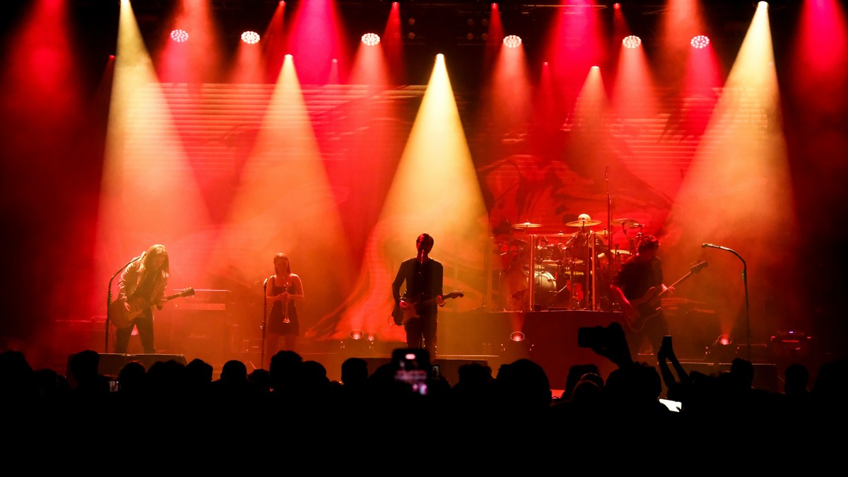 Band performing on a large red-lit stage