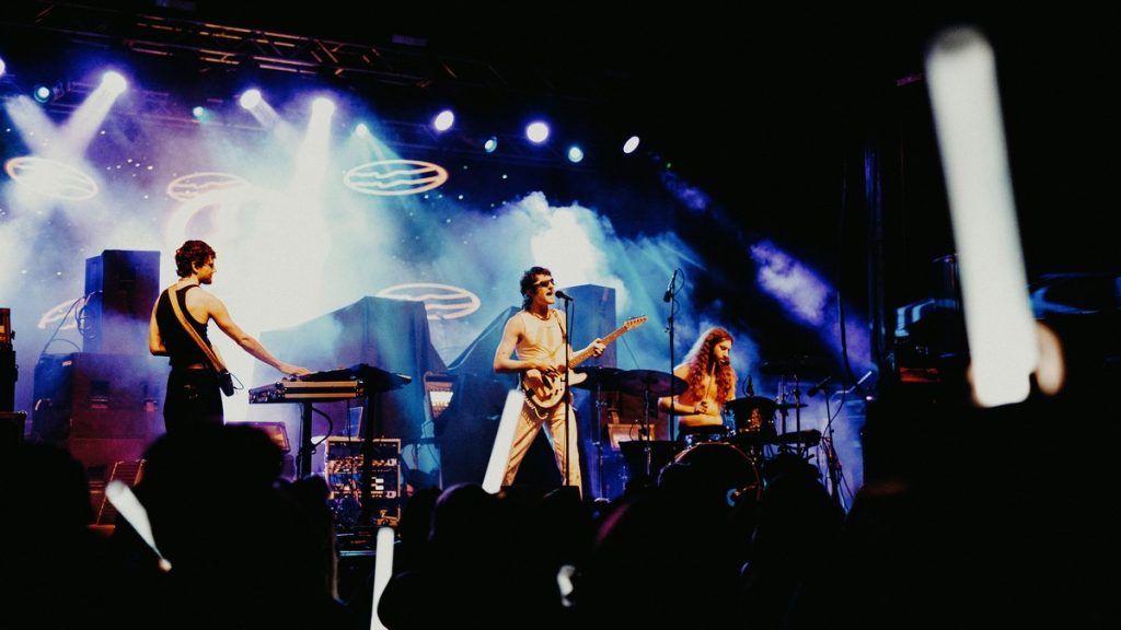 A band performing as fans hold up light sticks