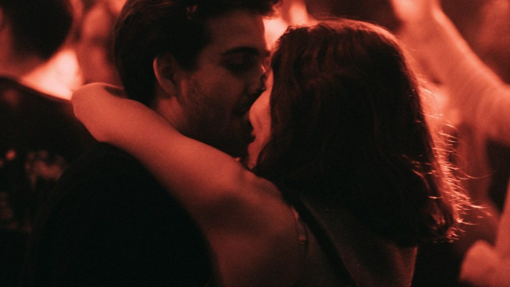 Couple embracing at a concert in red light