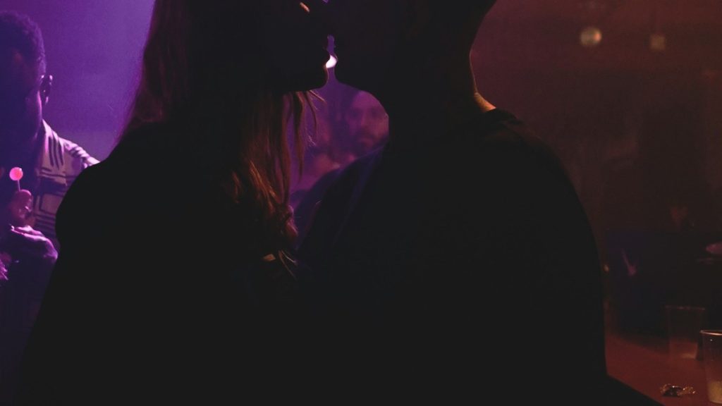 Couple kissing in silhouette at a concert